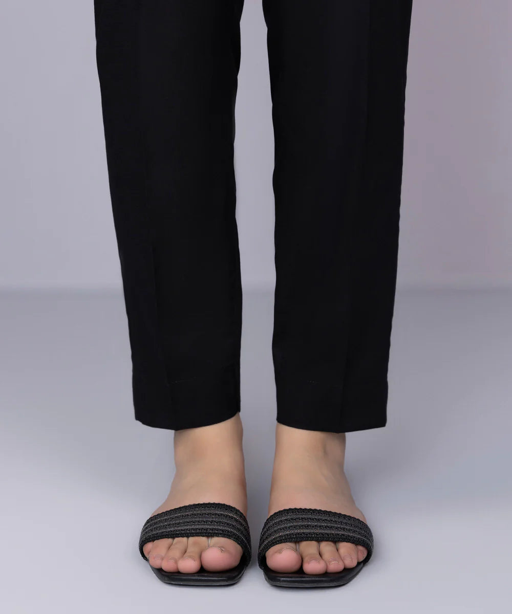 a person wearing a pair of black sandals