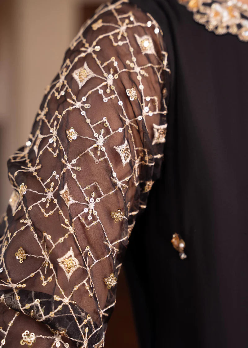 a close up of a person wearing a black and gold dress