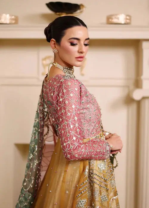 Profile shot of Organza Maxi Dress highlighting pink embroidered bodice and shimmering golden skirt, ideal for festive occasions.