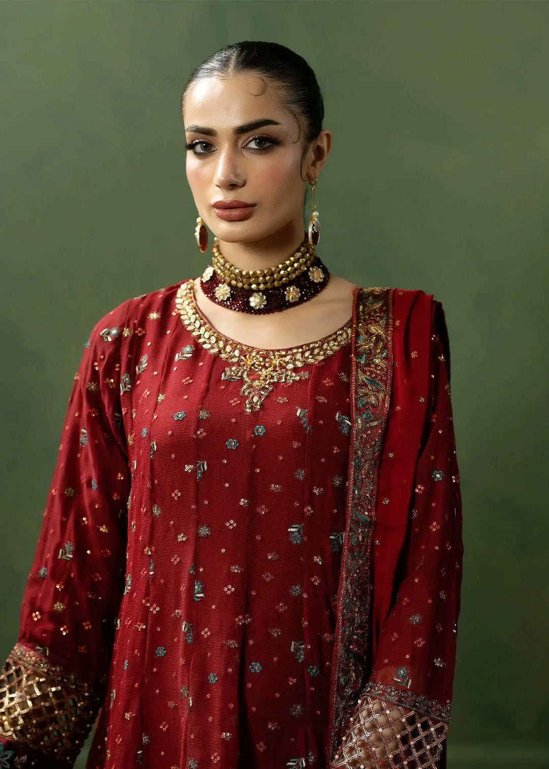 Close-up of RANGREZA RED red colour dresses pakistani showing detailed neckline embroidery and rich fabric texture of the frock and dupatta.