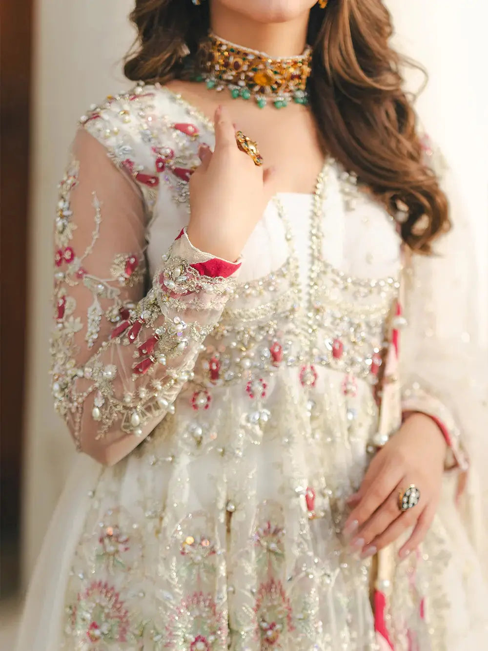 Close-up of embroidered white net fabric with pearl, sequin, and embroidery embellishments, suitable for wedding attire