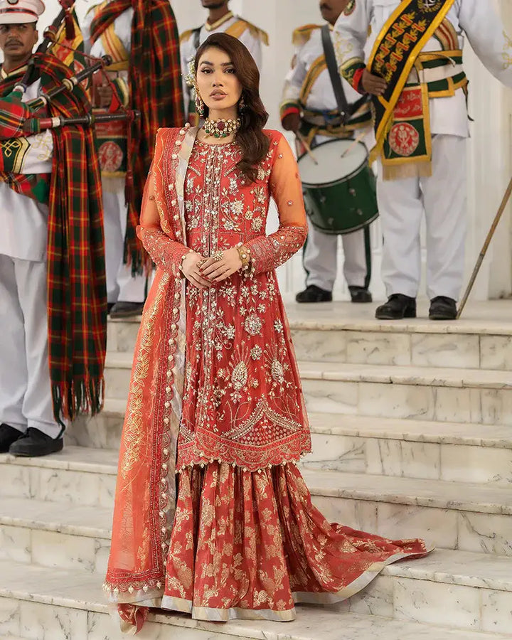AROOSH Wedding Wear AR-103-2200 features a red peplum shirt with intricate naqshi and dabka embroidery, paired with a viscose ghararah and organza dupatta. Ideal for Pakistani wedding events, this traditional outfit blends elegance with festive charm.