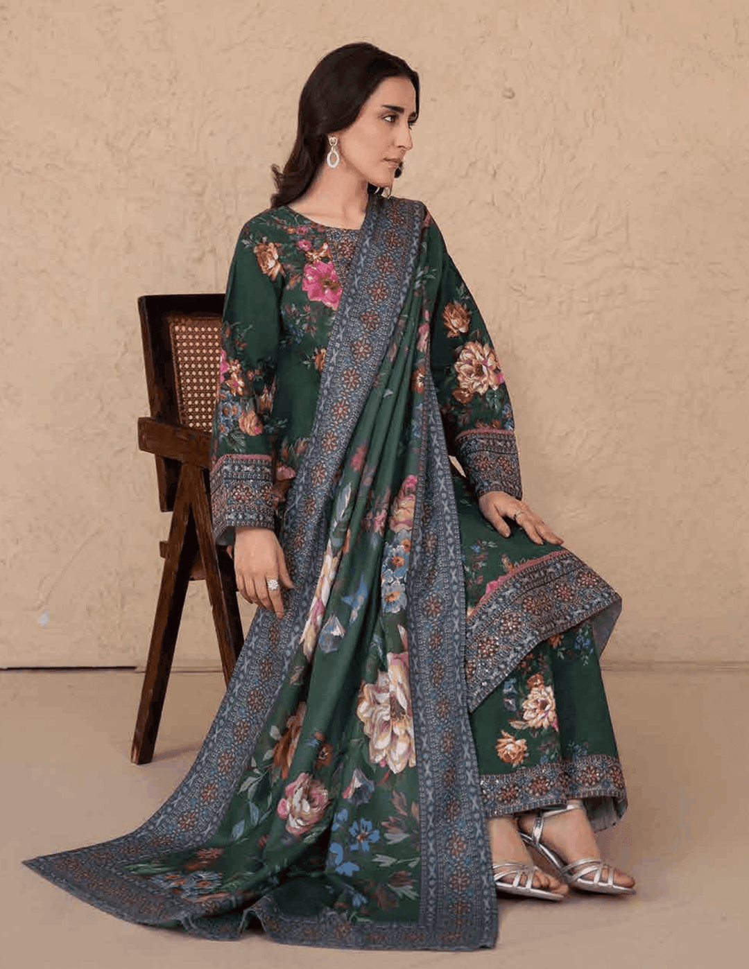 Seated model wearing RANGREZA ML-195-5401 festive Pakistani winter wear with printed shawl draped over floral kurta and pants.