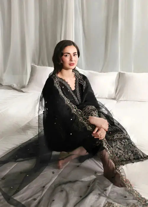 Seated woman in black embroidered kurta with dupatta for traditional look