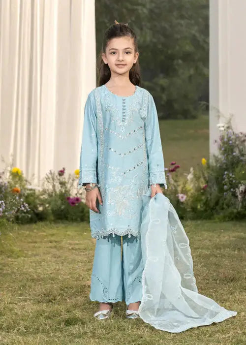 Young girl in light blue traditional dress with embroidery, holding a dupatta, outdoor garden setting