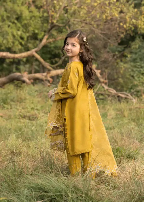 Girl in yellow traditional outfit holding flower outdoors