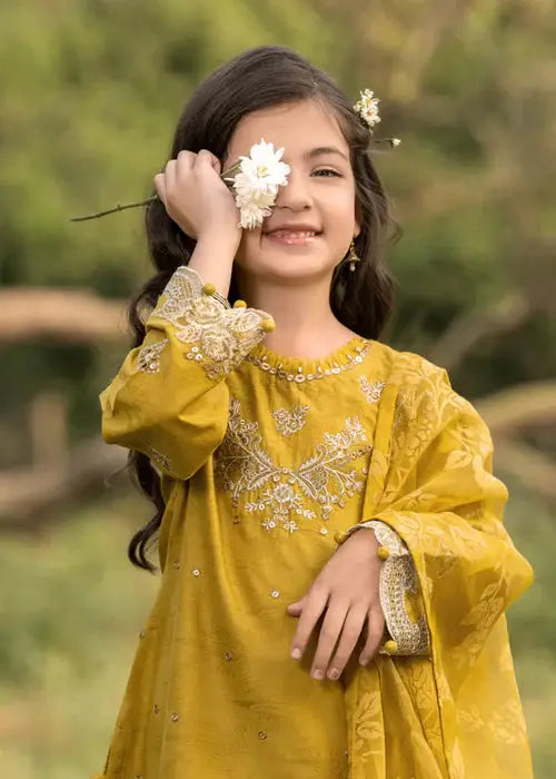 Smiling girl in yellow embroidered dress with floral hair accessory