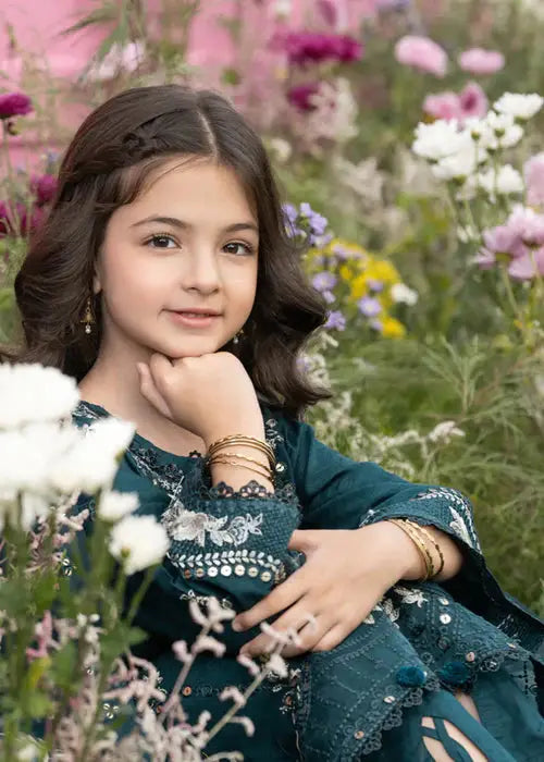 Close-up of girl with floral garden background in dark green embroidered dress