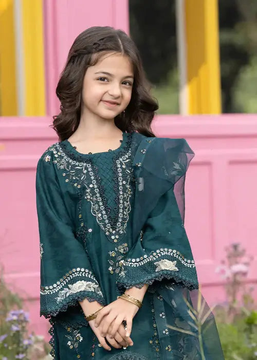 Girl smiling in dark green embroidered dress with floral garden background