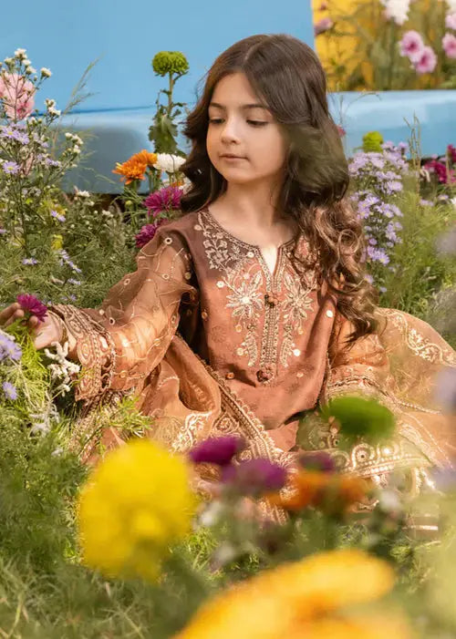 Young girl in traditional embroidered dress among colorful flowers