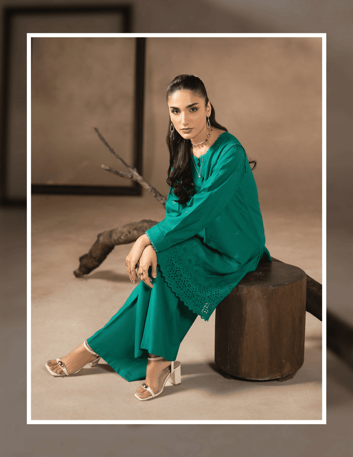 Model seated wearing RANGREZA EA-47-3802 two piece outfit, highlighting the intricate detailing on the kurta hem and relaxed winter styling.