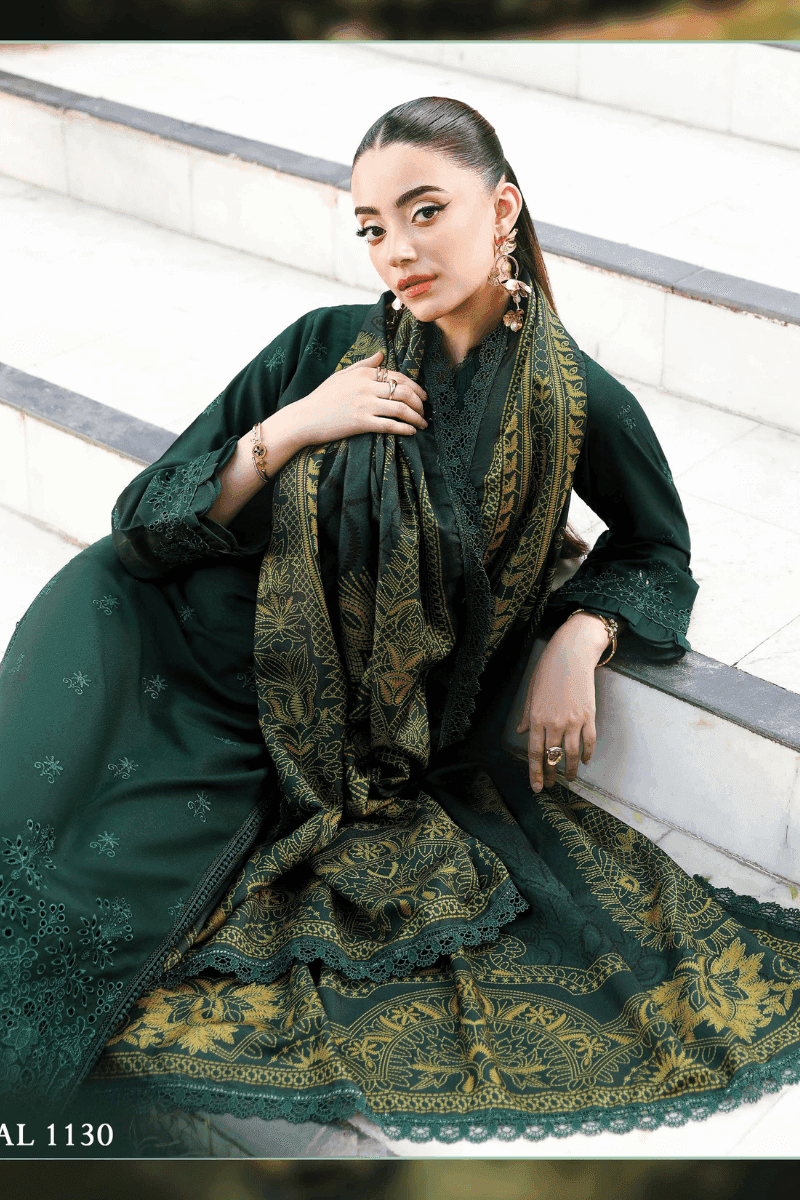 Model reclining in rangreza AL-1130 green embroidered outfit with ornate wool shawl, highlighting intricate fabric details.