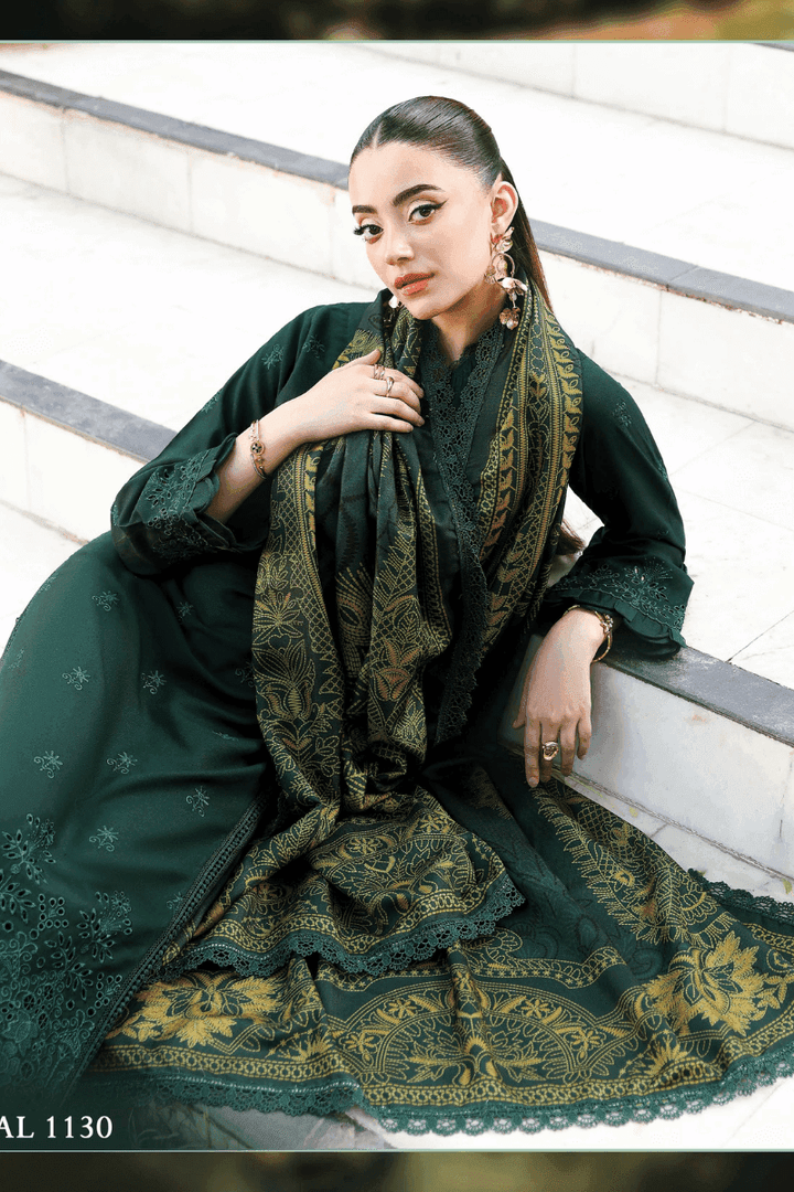 Model reclining in rangreza AL-1130 green embroidered outfit with ornate wool shawl, highlighting intricate fabric details.