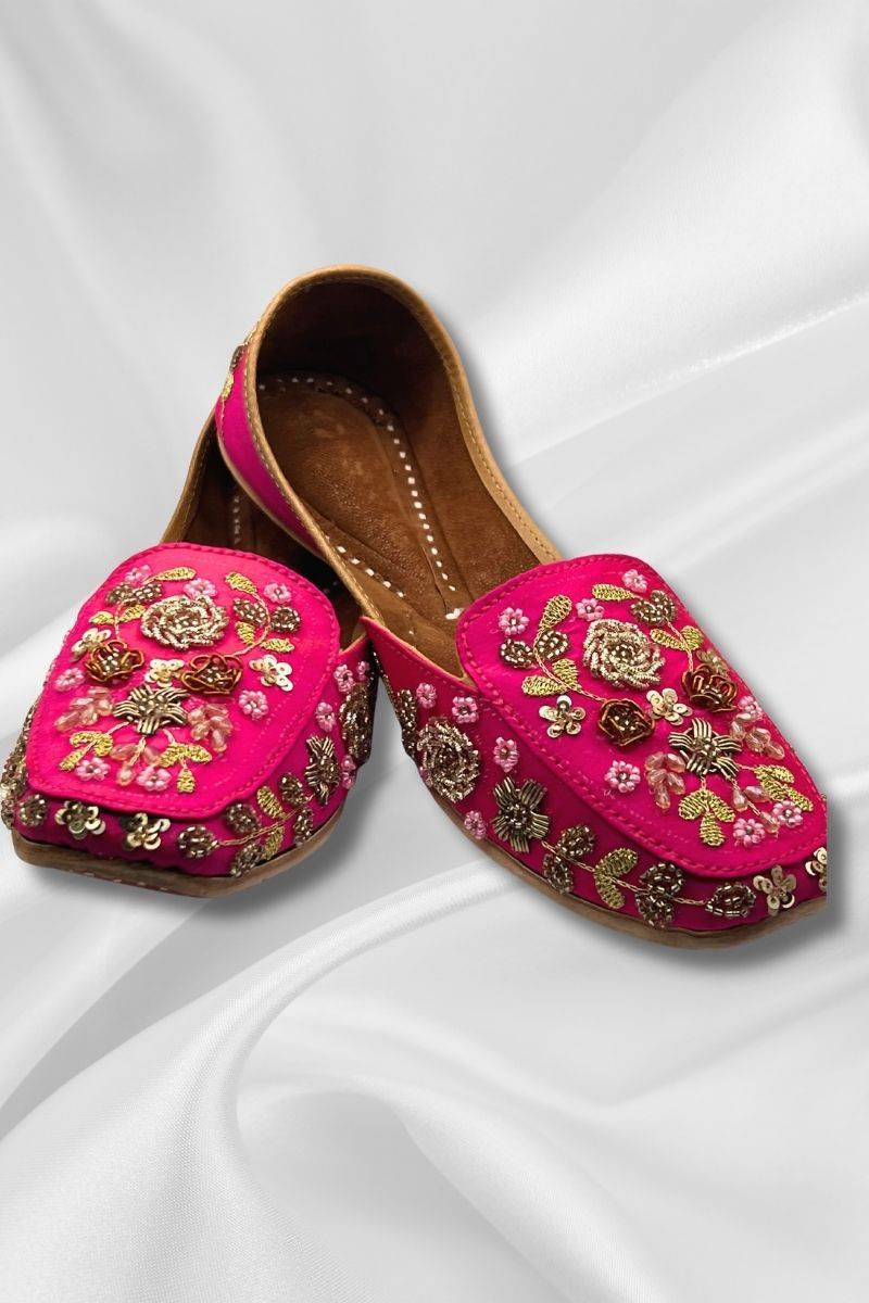 Aafreen Pink Jutti featuring vibrant fuchsia fabric with intricate gold and floral embroidery, ideal for traditional festive wear.