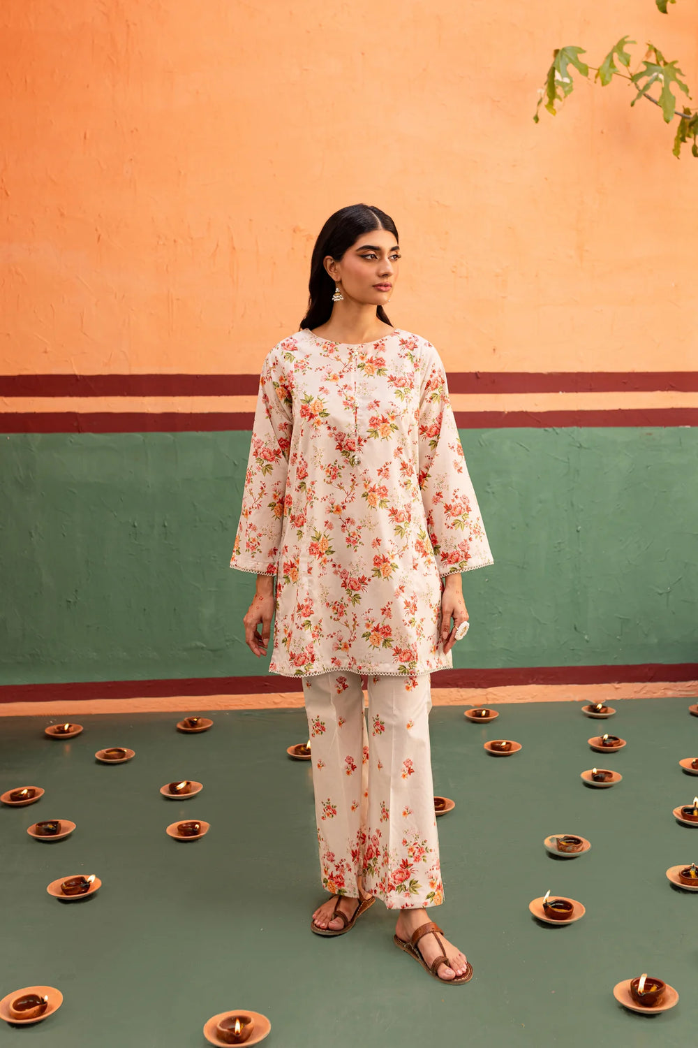 a BATIK READY TO WEAR woman standing in front of a wall with plates on it