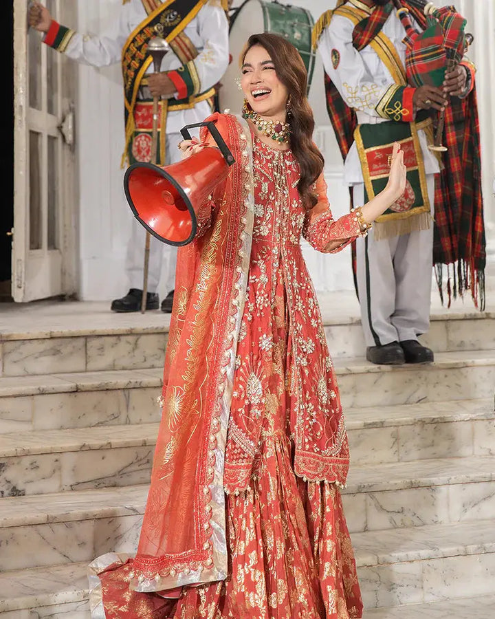 Pakistani wedding dress by AROOSH AR-103-2200 showcases a heavily embroidered red peplum with gold motifs, styled with a vibrant organza dupatta and ghararah. Perfect for bridal or festive wear.
