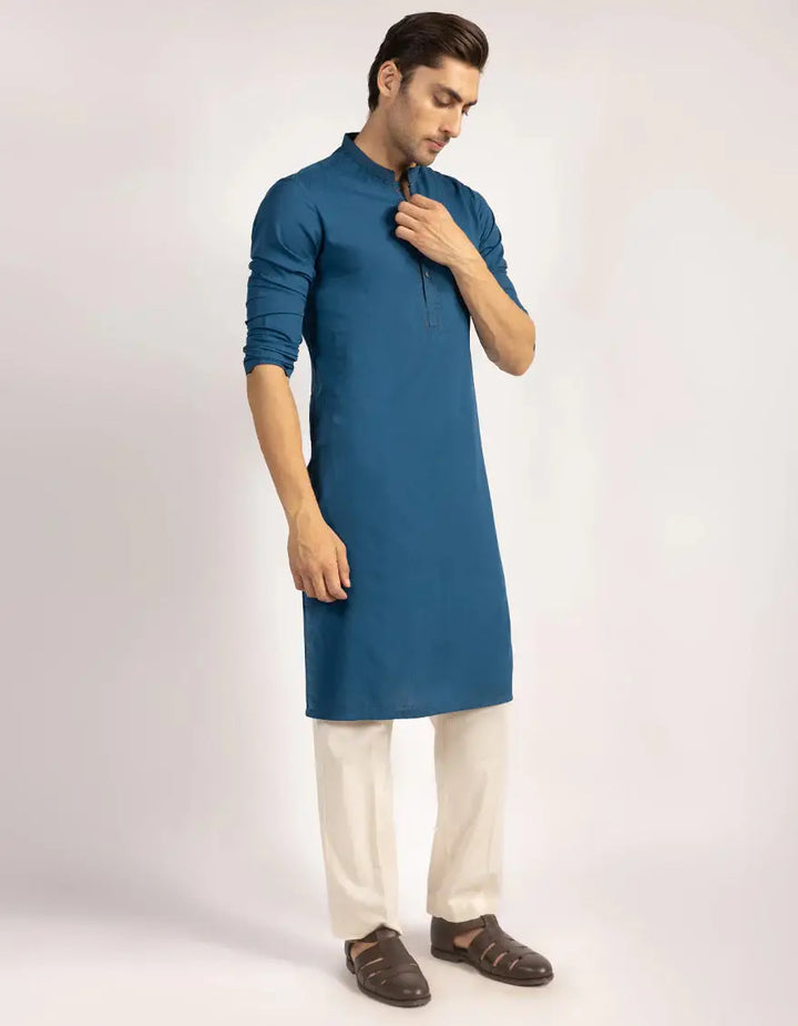 Side view of Junaid Jamshed J. Kurta - Blue Semi-Formal, styled with white trousers, showcasing its elegant silhouette and modern fit.