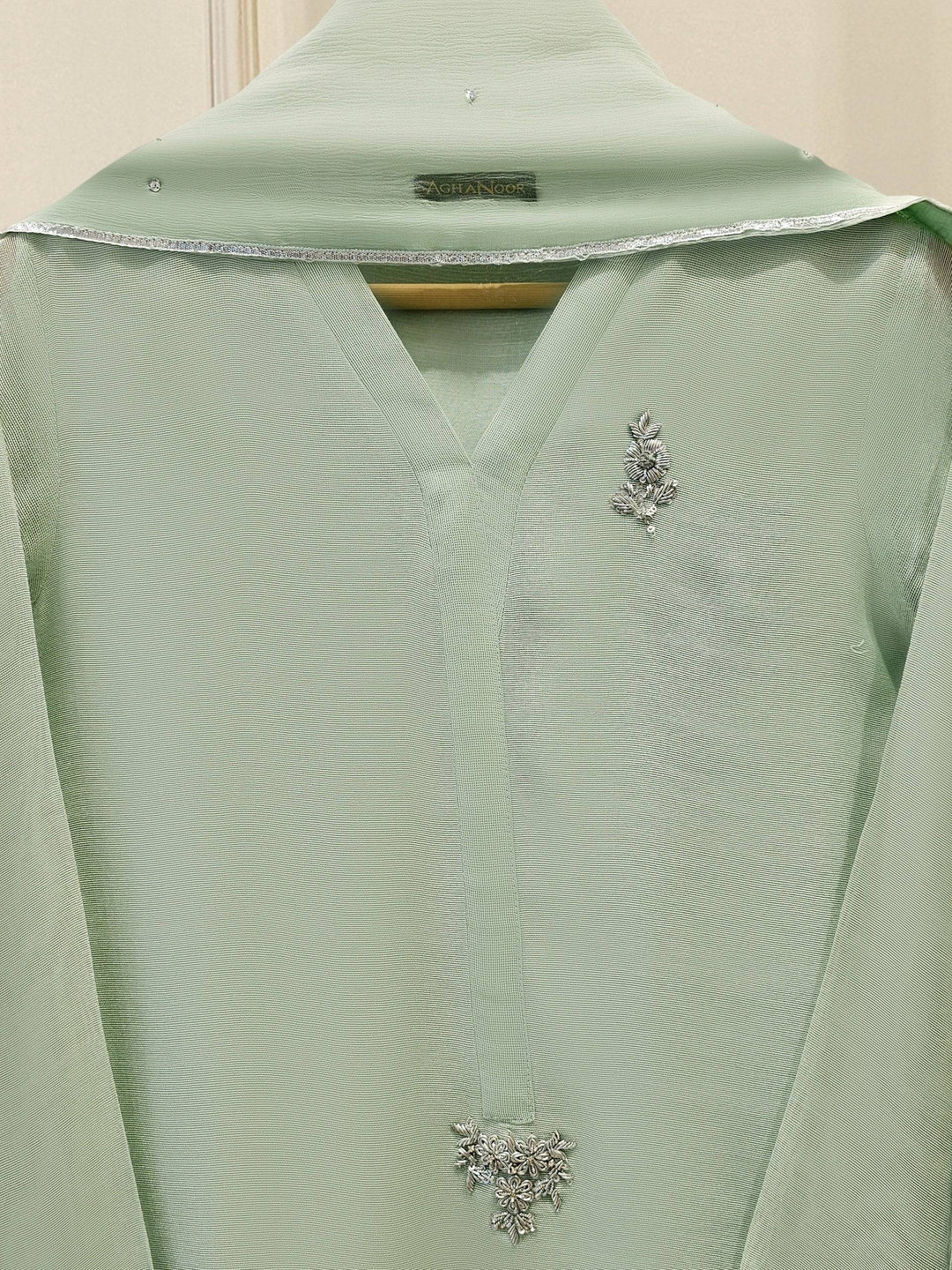 Close-up of Agha Noor embroidered neckline and chest detailing on mint green cotton net shirt for refined elegance.