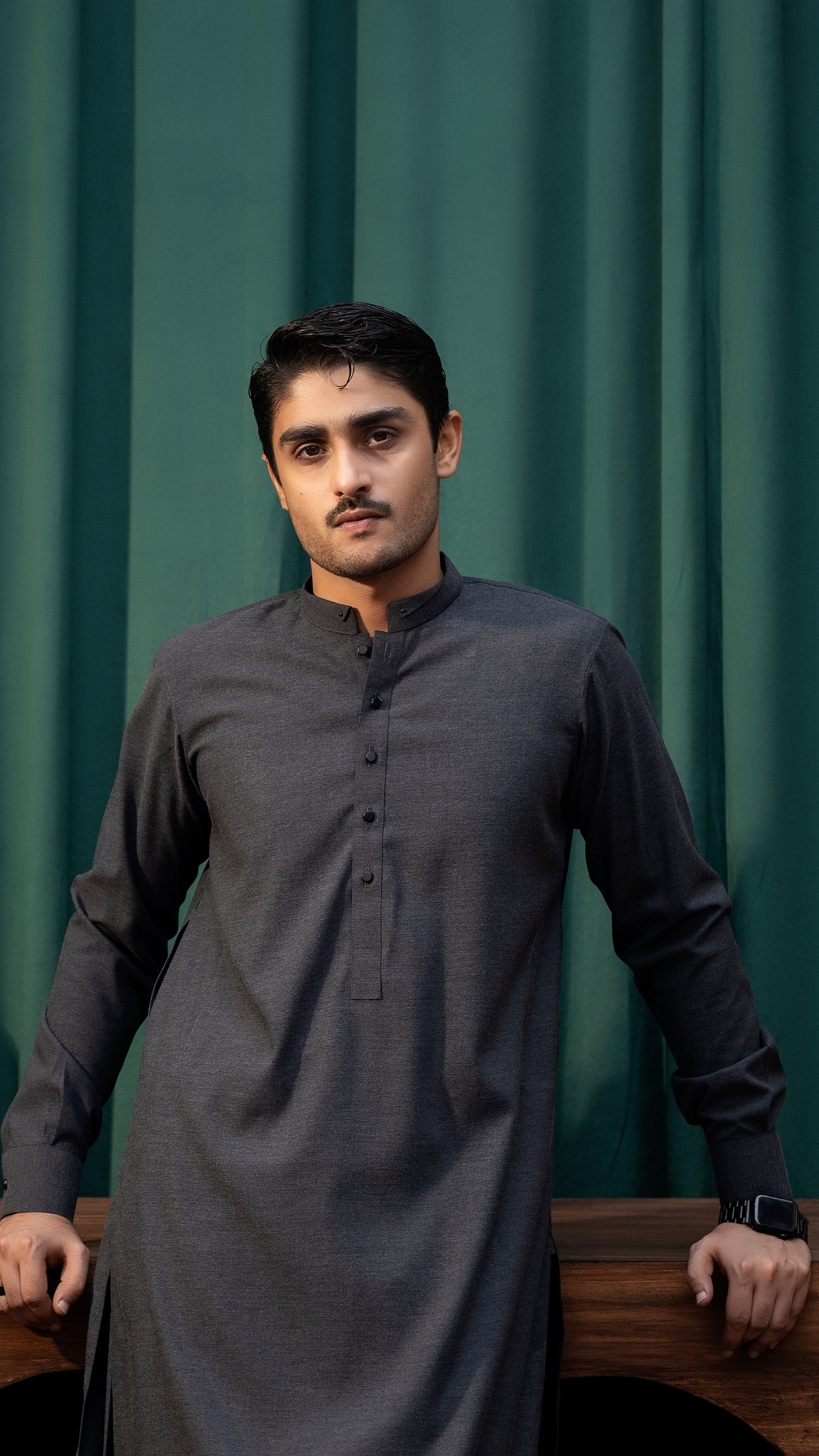 Model wearing dark grey Rangreza kurta MA-07-55, showcasing its elegant traditional design against a green backdrop.