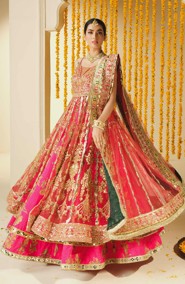 Pakistani bridal lehenga by MARYUM AND MARIA in vibrant pink with intricate gold threadwork and flared silhouette, perfect for festive occasions.
