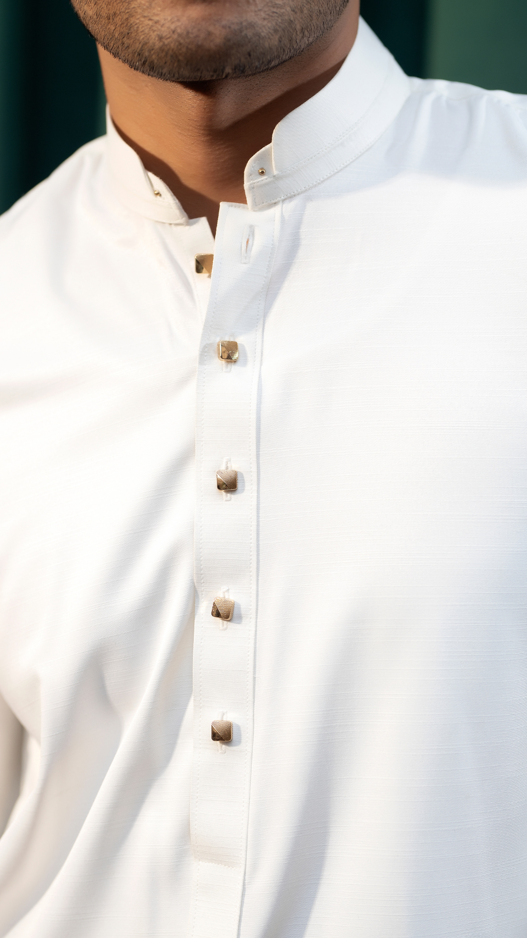 Detailed shot of the buttoned neckline on Rangreza's white men's kurta pajama, emphasizing craftsmanship and design.