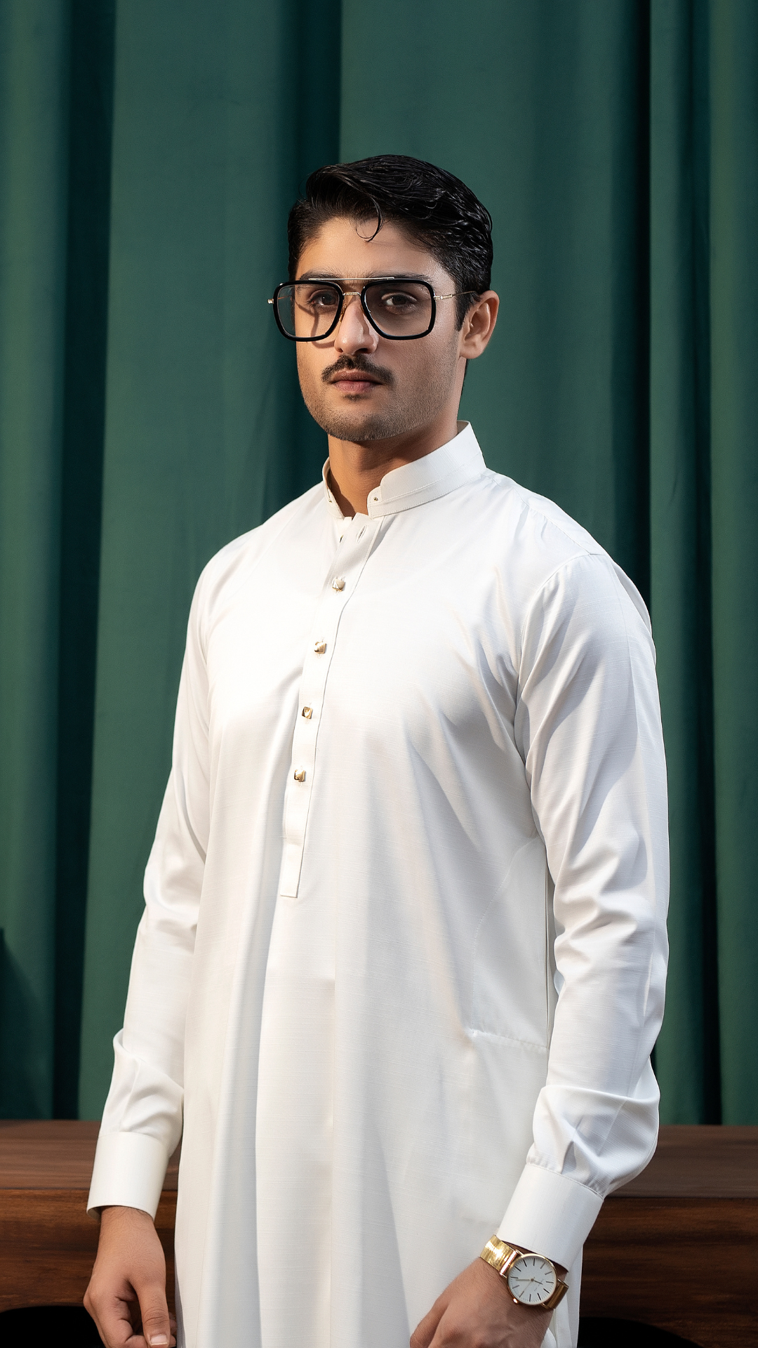 Model wearing Rangreza's white men's kurta pajama, styled with a watch, showcasing a modern yet traditional look.