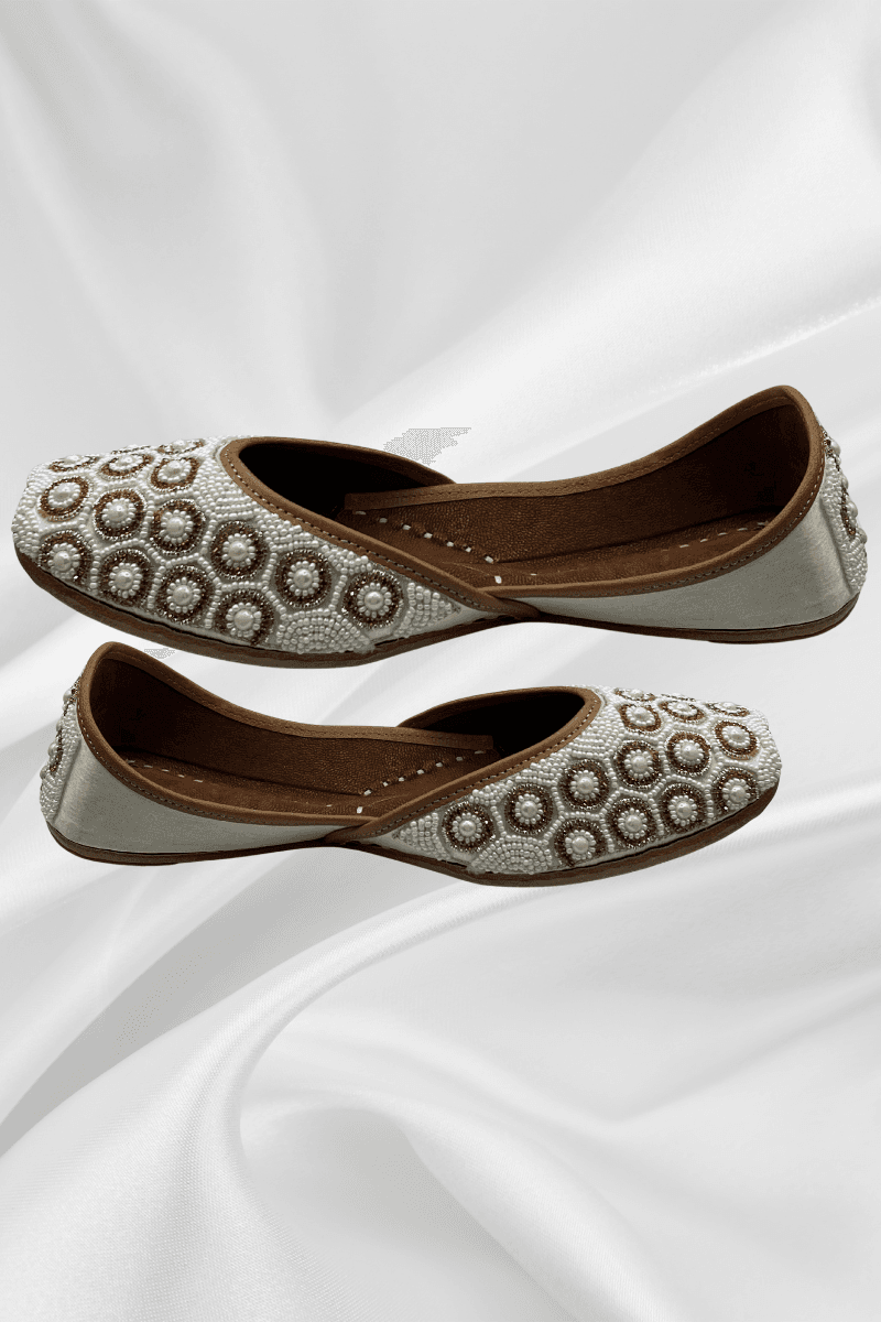 Ivory Pearl Jutti featuring intricate circular beadwork, handcrafted khussa flats for women in bridal and elegant footwear styles.