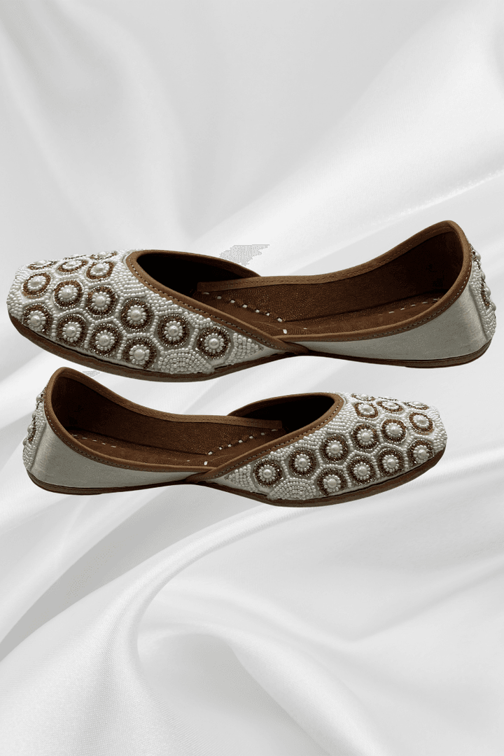 Ivory Pearl Jutti featuring intricate circular beadwork, handcrafted khussa flats for women in bridal and elegant footwear styles.