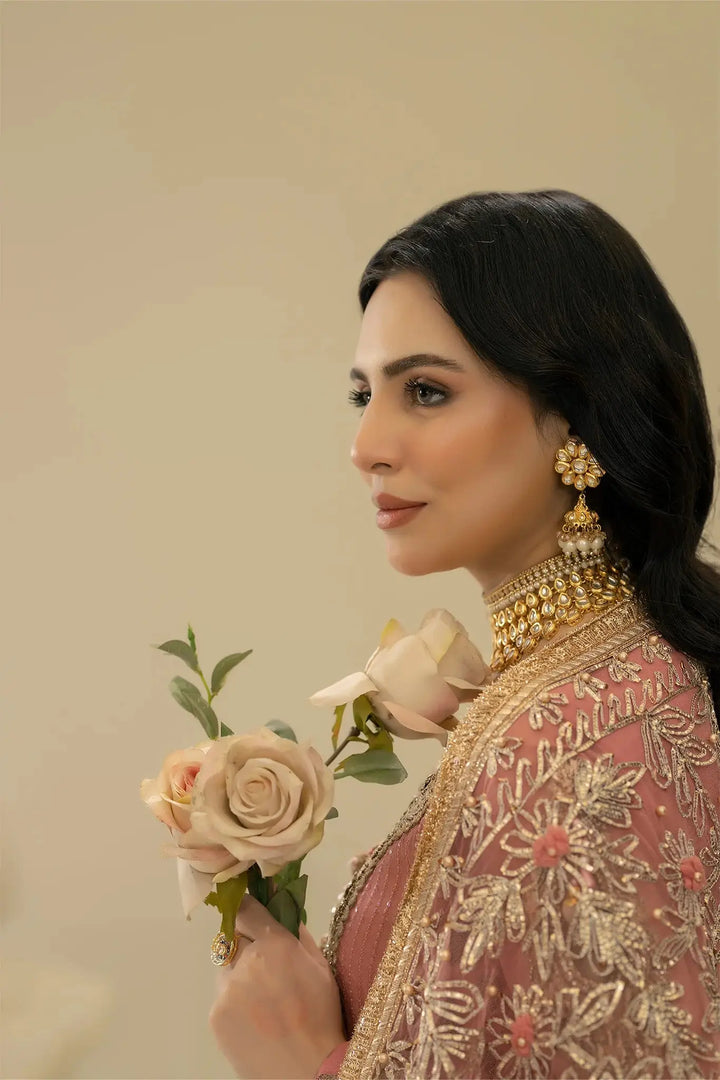 Side profile of model in KHUDA BAKSH M-109 Pink, wearing floral earrings and holding roses, emphasizing feminine elegance.