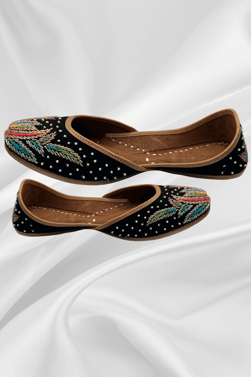 Side view of Noorani Black Jutti featuring colorful thread embroidery and dotted detailing, perfect flat footwear for girls' ethnic fashion.