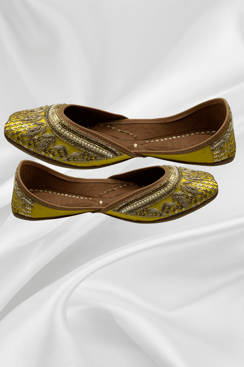 Side profile of Zeenat Yellow Jutti - handcrafted flat shoes with gold sequin work and pearl edging, perfect for traditional and formal occasions.