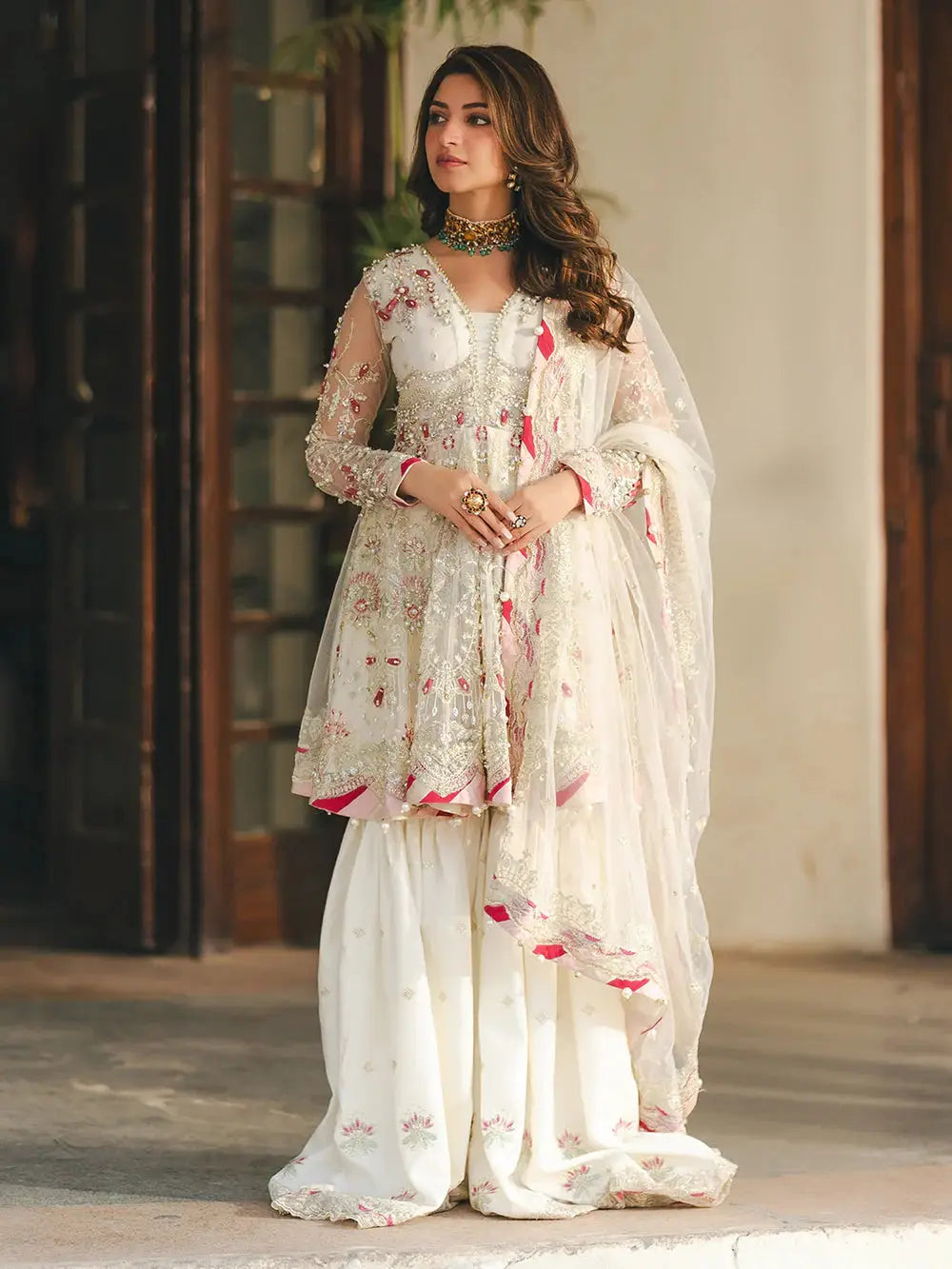 Elegant white embroidered net peplum with sequin, adda, naqshi, dabka, pearls, crystals, chainwork, lace, and paranda tassels, paired with embroidered white ghararah and dupatta for wedding attire