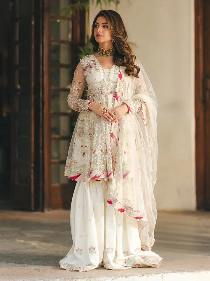 Elegant white embroidered net peplum with sequin, adda, naqshi, dabka, pearls, crystals, chainwork, lace, and paranda tassels, paired with embroidered white ghararah and dupatta for wedding attire