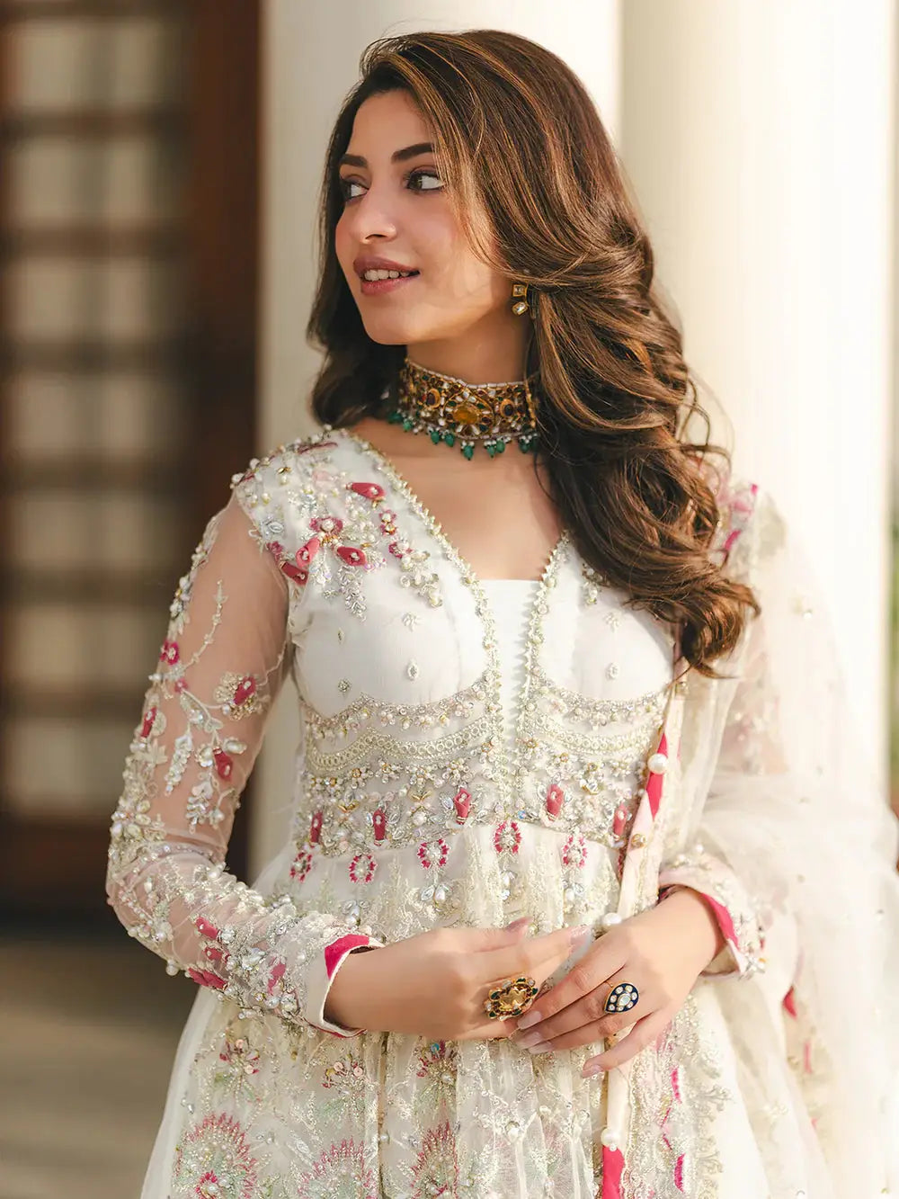Elegant embroidered white dress with intricate pearl, sequin, and embroidery details, styled with jewelry for special occasions