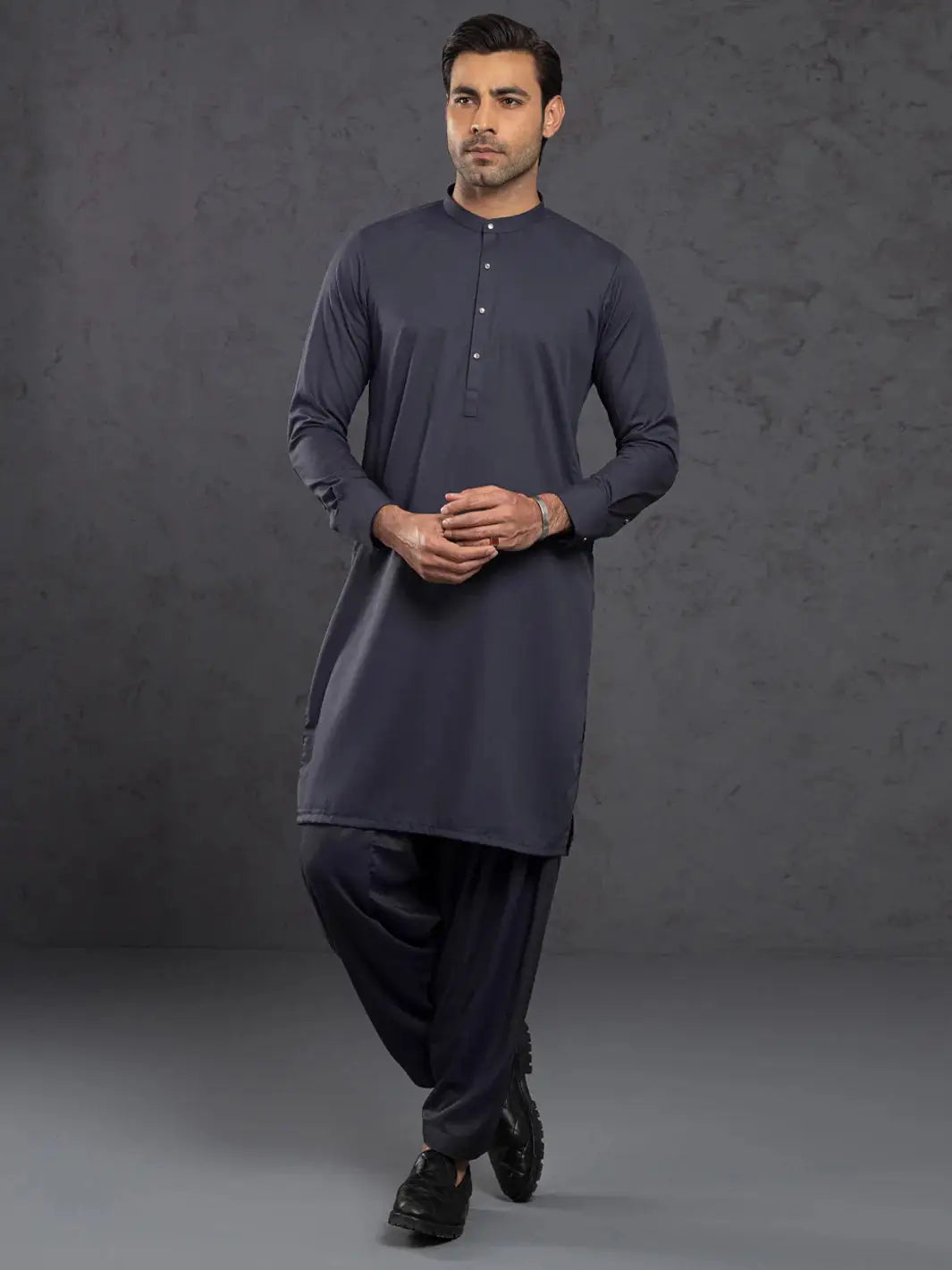 Man wearing navy blue kurta with mandarin collar and button placket, full sleeves, traditional attire for men