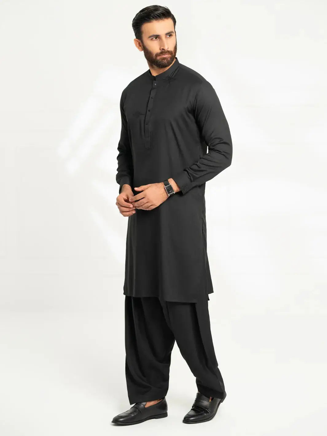 Full-length of man in black kurta with matching shalwar, formal dress