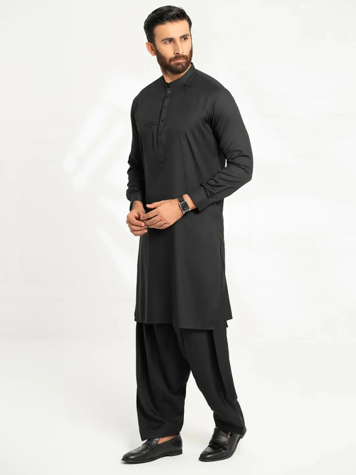 Full-length of man in black kurta with matching shalwar, formal dress