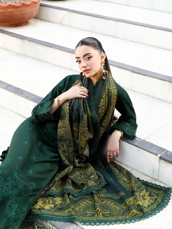 Elegant pose in rangreza AL-1130 green Pakistani suit with detailed embroidery and luxurious printed wool shawl on stairs.