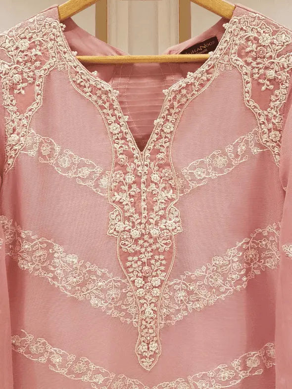 Close-up of intricate embroidery on pink shirt