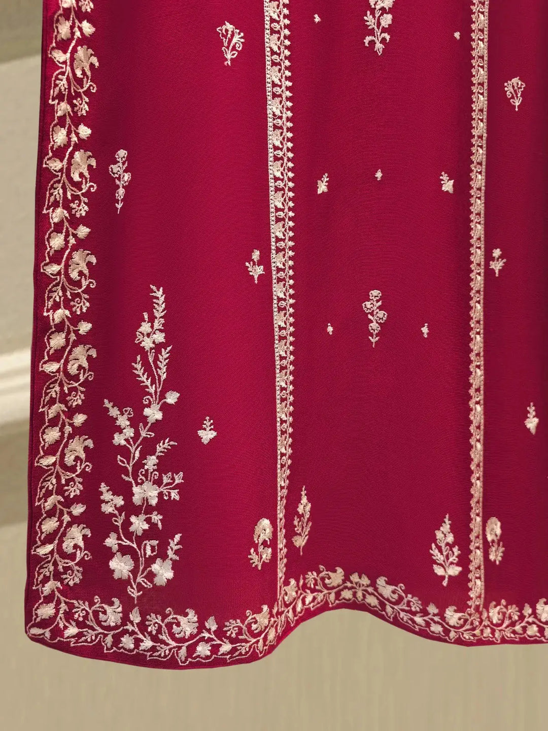 Side hem embroidery of AGHA NOOR Cotton Suit showcasing elegant floral motifs and border on deep pink fabric.