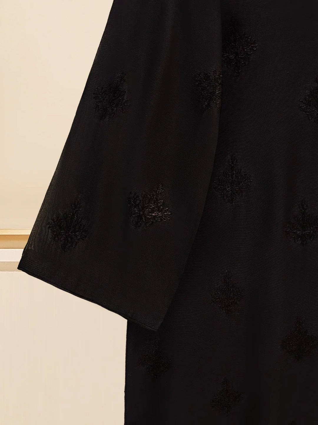 Close-up of black embroidered sleeve detail