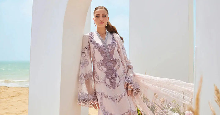 Model wearing 3 piece suit women's Embroidered Lawn Suit | AL-4309 in pastel pink with lavender embroidery, posing under white arch by the sea.