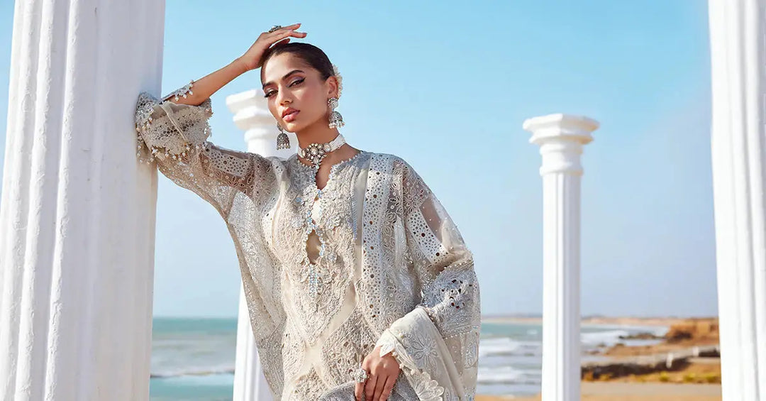Model leaning on column in AL-4287 Embroidered Suit with ocean backdrop. Features 3D floral embroidery and luxurious fabric.