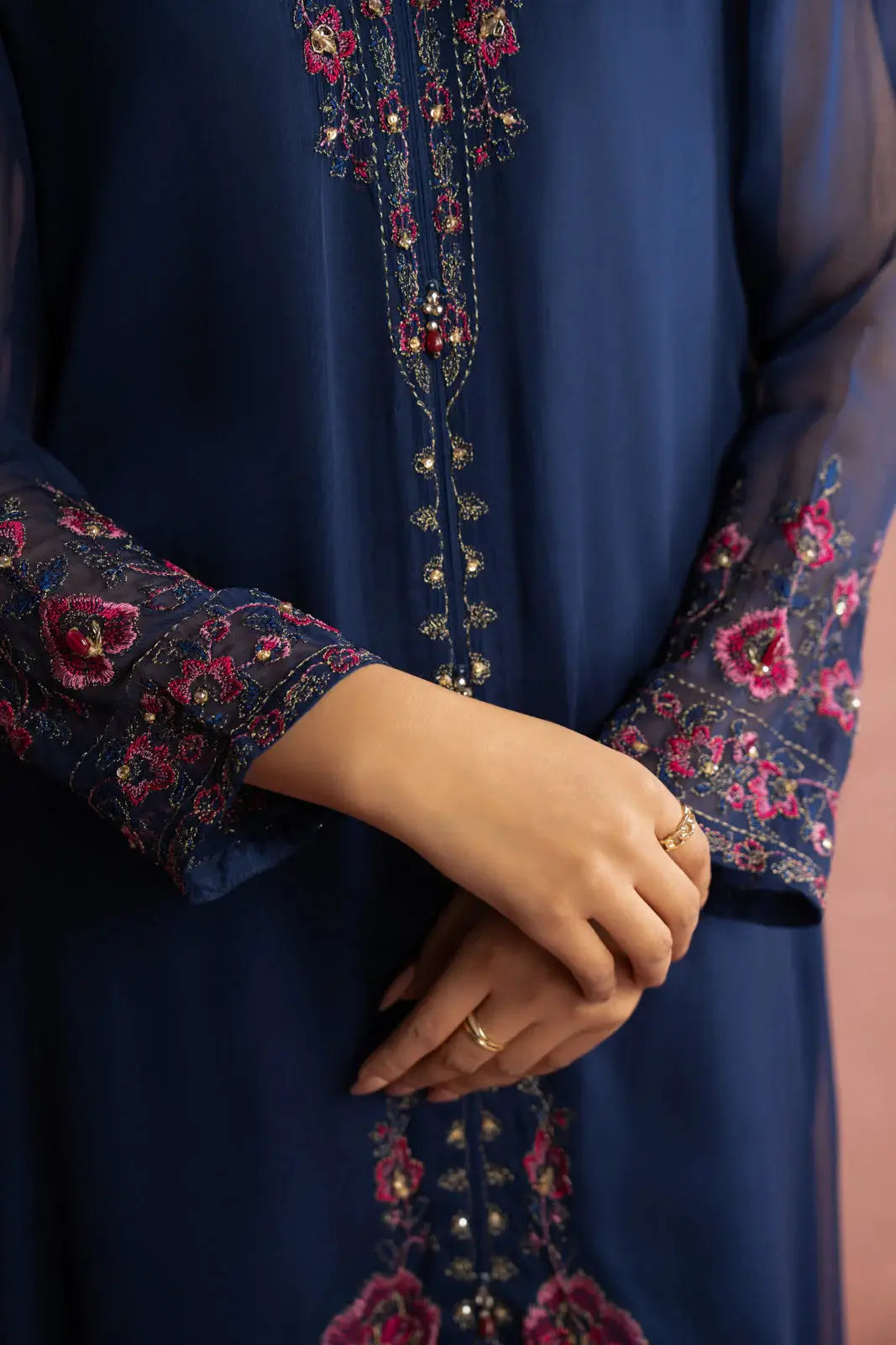 Detailed embroidery on CHINYERE 3 Piece Suit's sleeve and shirt hem in pink floral patterns, enhancing the premium chiffon fabric.