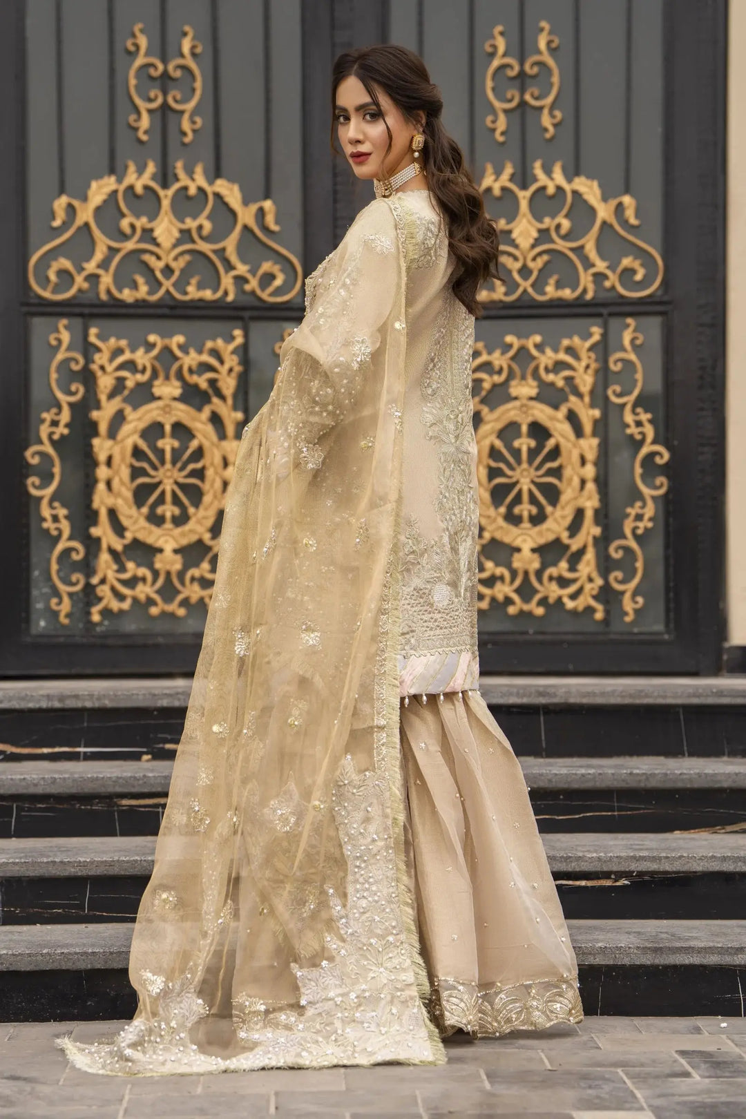Side-back angle of AROOSH Kundan Masoori outfit highlighting the embroidered dupatta and flared gharara in a traditional Pakistani style.