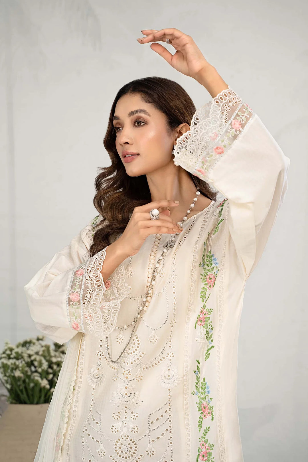 a Pakistani woman in a white dress posing for a picture