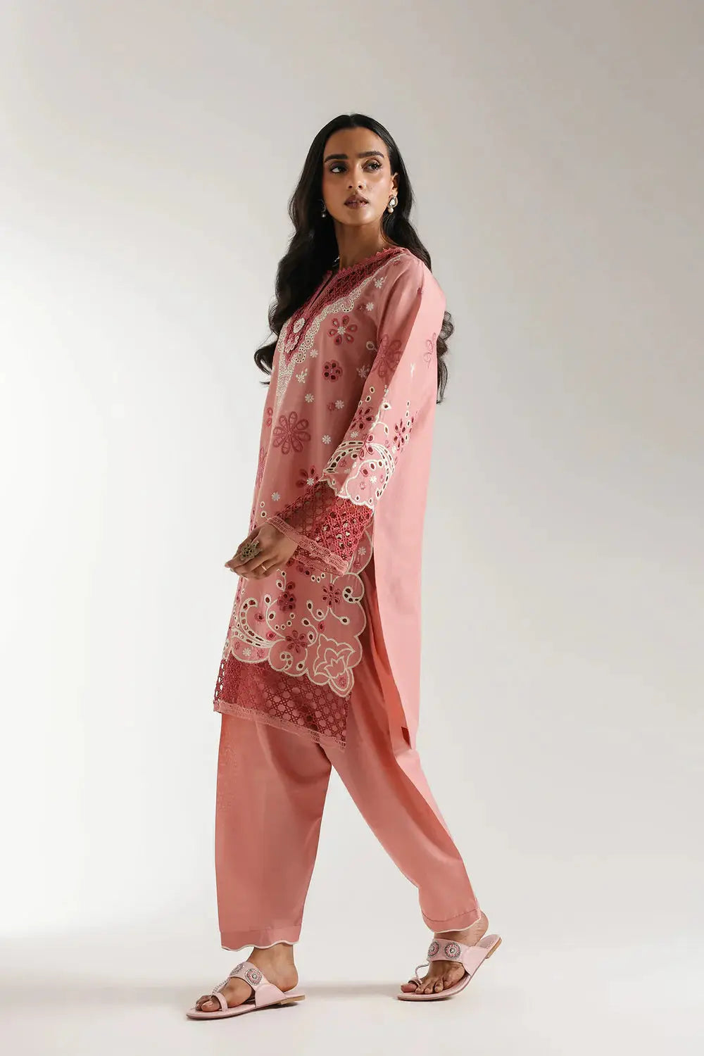 Blush coral EMBROIDERED SUIT E3120 with floral embroidery and cutwork sleeves, shown in a side walking pose for summer fashion appeal.