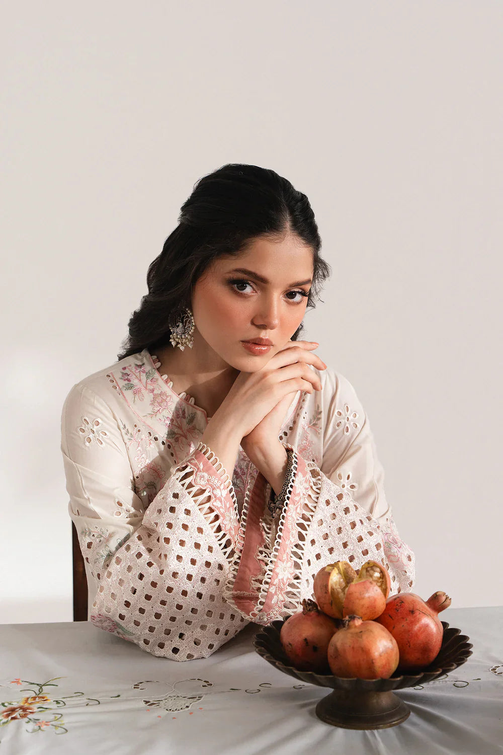Detailed view of ETHNC EMBROIDERED SUIT - Ethnic USA showing floral embroidery and cutwork on sleeves, paired with statement earrings.