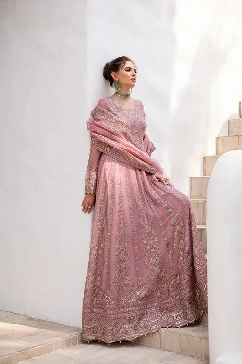 Model posing in MARYUM AND MARIA embroidered chiffon dress, styled with traditional jewelry and soft pink hues for Pakistani formal fashion.