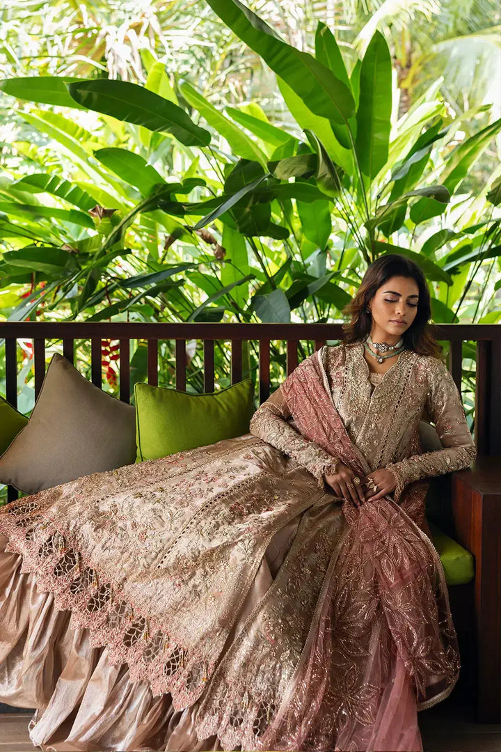 Model lounging in ROHANA-SRF25-03 by Saira Rizwan, showcasing gold-toned embroidered organza shirt and zari dupatta in a relaxed setting.